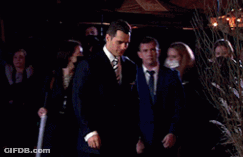 Man In Suit And Tie Walking In Front Of Crowd GIF