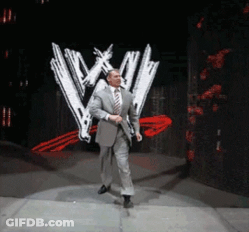 Man In Suit And Tie Walking Past WWE Logo GIF