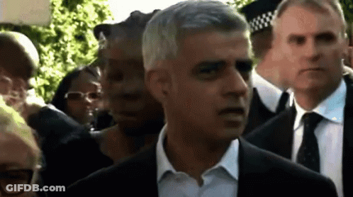 Man In Suit And Tie Walking Through Crowd GIF