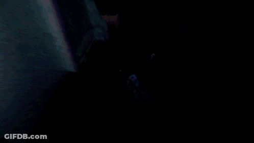 Man In Suit And Tie Walking Through Dark Room GIF