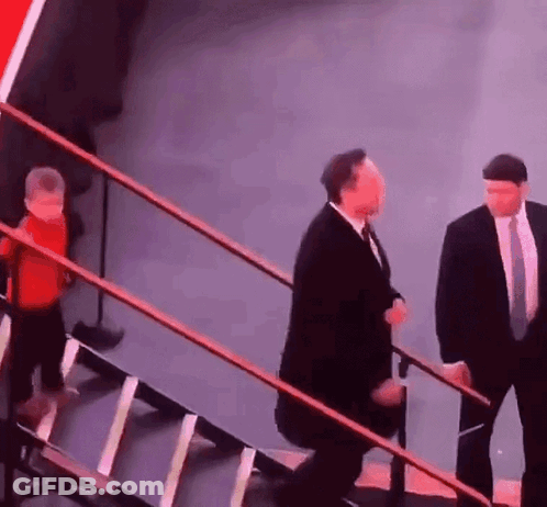 Man In Suit And Tie Walking Up Stairs With Child GIF