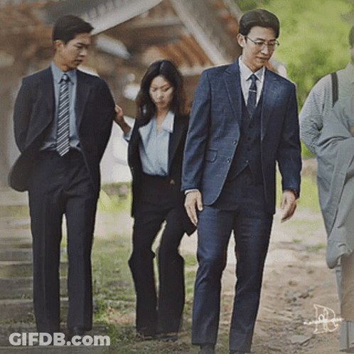Man In Suit And Tie Walking With Two Men And Woman GIF