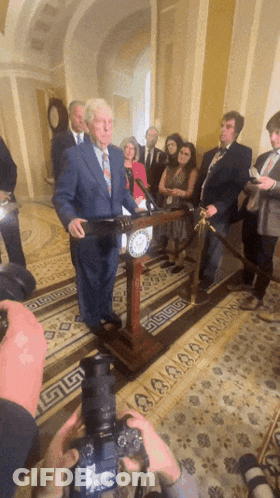 Man In Suit And Tie Walking With Woman In Black Shirt GIF