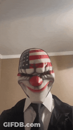 Man In Suit And Tie Wearing Clown Mask GIF