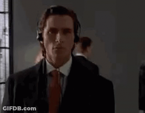 Man In Suit And Tie Wearing Headphones By Window GIF