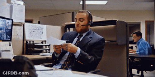 Man In Suit And Tie Wearing Headset Looking At Paper GIF