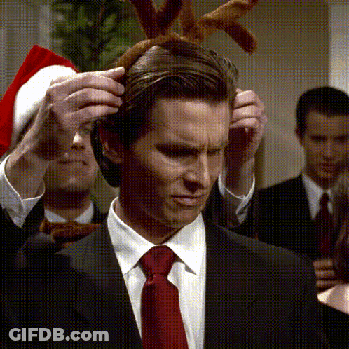 Man In Suit And Tie Wearing Reindeer Antlers GIF