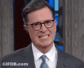 Man In Suit And Tie With Glasses Making Funny Face GIF