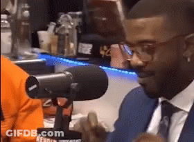 Man In Suit And Tie With Glasses Talking Into Microphone GIF