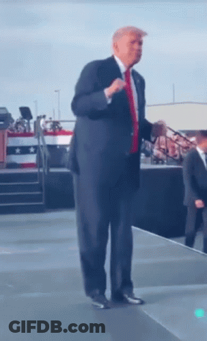 Man In Suit And Tie With Microphone On Stage GIF