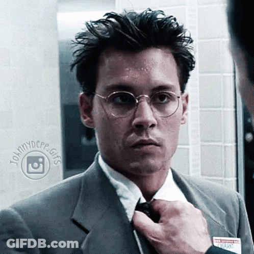 Man In Suit And Tie With Name Tag Saying Johnnydcpp GIF