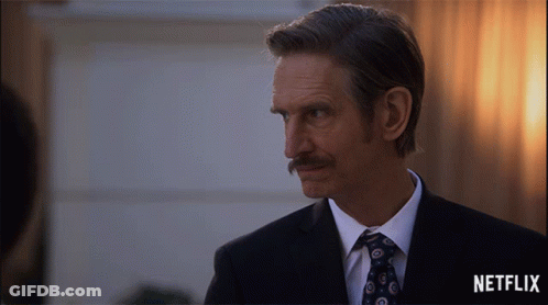 Man In Suit And Tie With Netflix Logo GIF