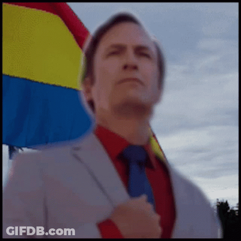 Man In Suit And Tie With Rainbow Flag GIF