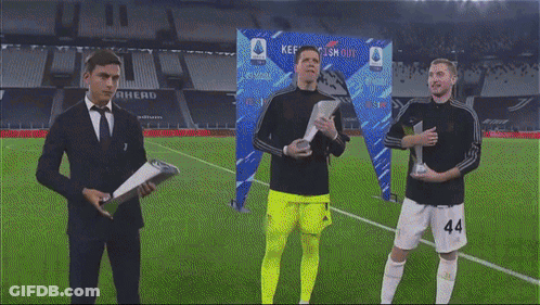 Man In Suit And Tie With Soccer Players Holding Trophies GIF