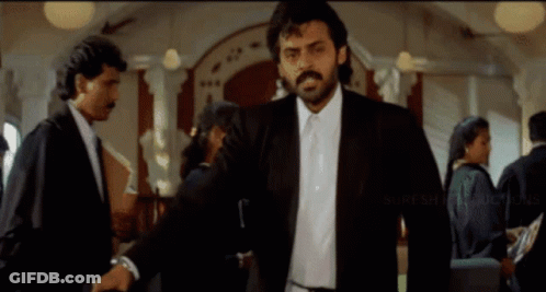 Man In Suit And Tie With Suresh Productions Logo GIF