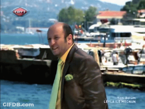 Man In Suit And Tie With TRT1 Logo Above Water GIF