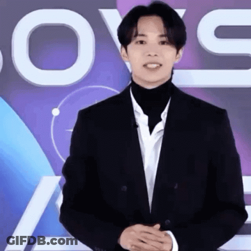 Man In Suit And Turtleneck With Love Sign GIF