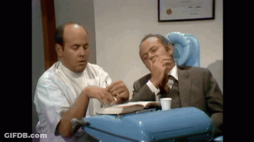 Man In Suit And White Coat Looking At Book GIF