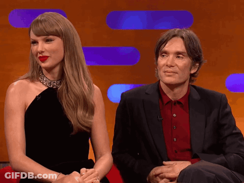 Man In Suit And Woman In Black Dress Sitting GIF