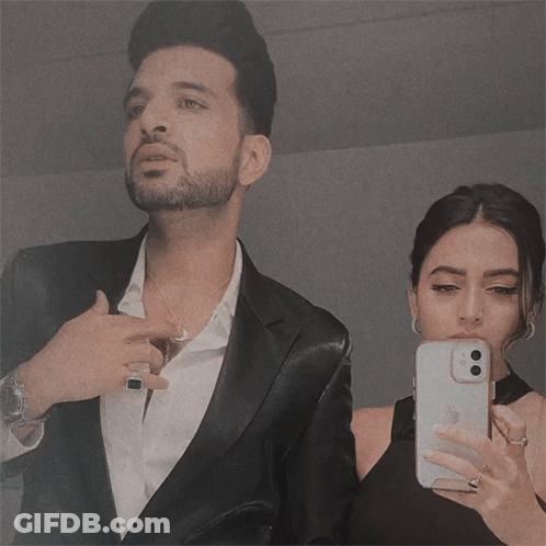 Man In Suit And Woman In Black Dress Taking Selfie GIF