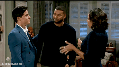 Man In Suit And Woman In Black Sweater Talking In Living Room GIF