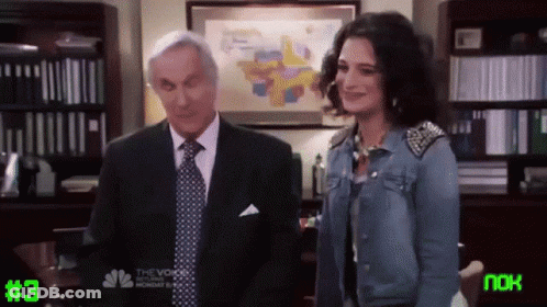 Man In Suit And Woman In Denim Jacket Next To #3 Screen GIF
