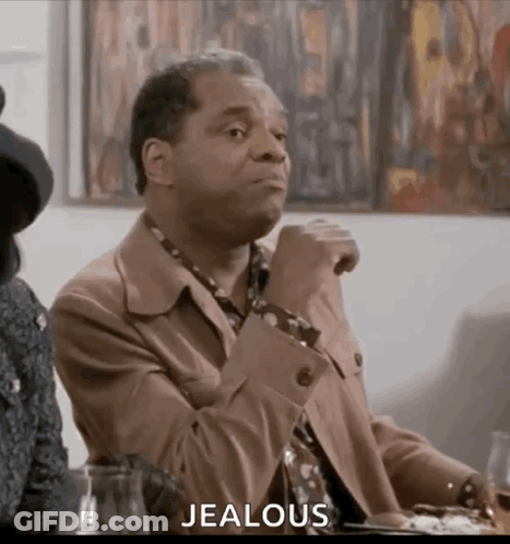 Man In Suit And Woman In Hat Sitting With Wine GIF