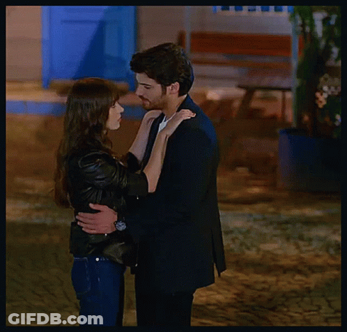 Man In Suit And Woman In Jacket Kissing GIF