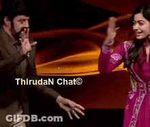 Man In Suit And Woman In Pink Dress Dancing Before Thirudan Chat Sign GIF