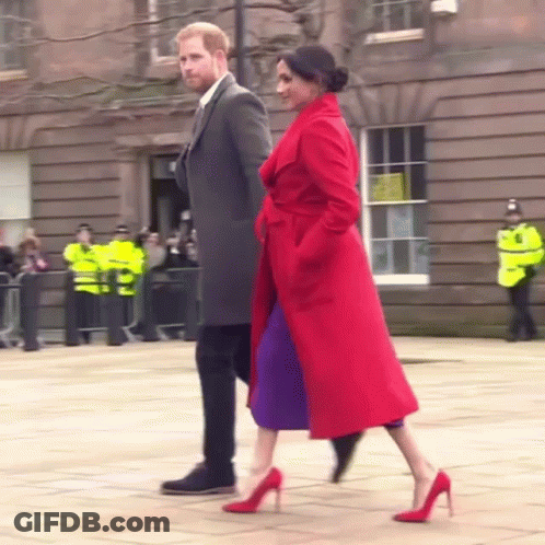 Man In Suit And Woman In Red Coat Walking GIF