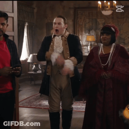 Man In Suit And Woman In Red Dress Standing Next To Each Other Saying Capcut GIF