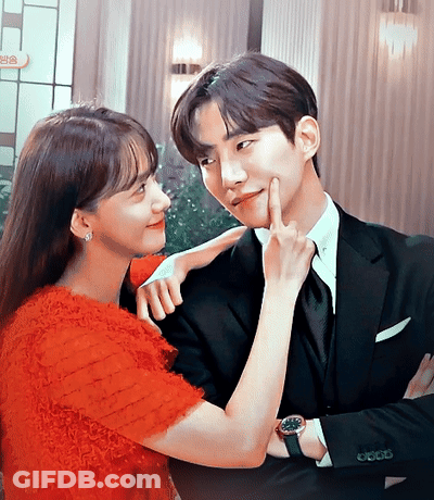 Man In Suit And Woman In Red Dress Touching His Face GIF