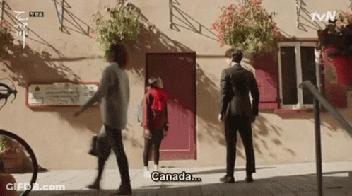 Man In Suit And Woman In Red Hoodie Saying Canada GIF