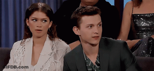 Man In Suit And Woman In White Jacket Sitting Together GIF