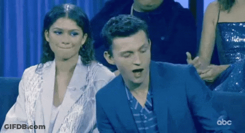 Man In Suit And Woman In White Jacket Sitting With ABC GIF