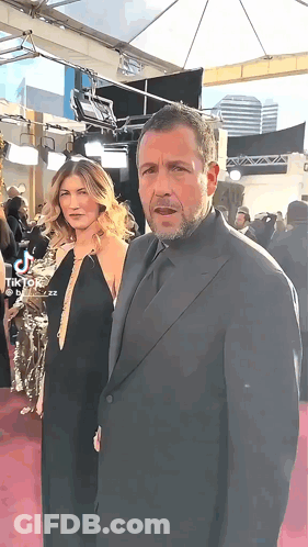 Man In Suit And Woman On Red Carpet GIF