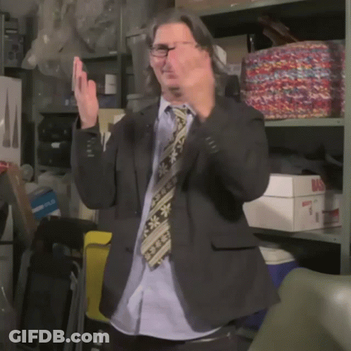 Man In Suit Applauding In Front Of Shelf Saying Bas GIF