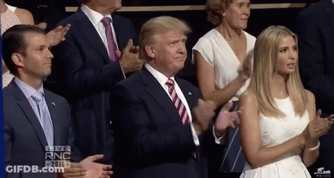 Man In Suit Applauding While Woman In White Dress Watches GIF