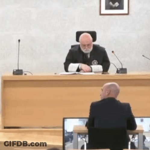Man In Suit At Courtroom Desk GIF