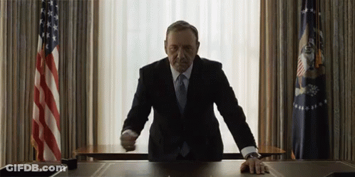 Man In Suit At Desk In Front Of Window GIF
