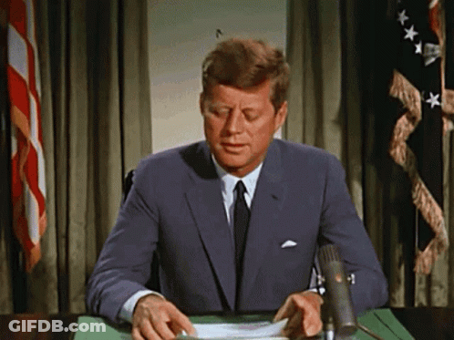 Man In Suit At Desk With Microphone GIF