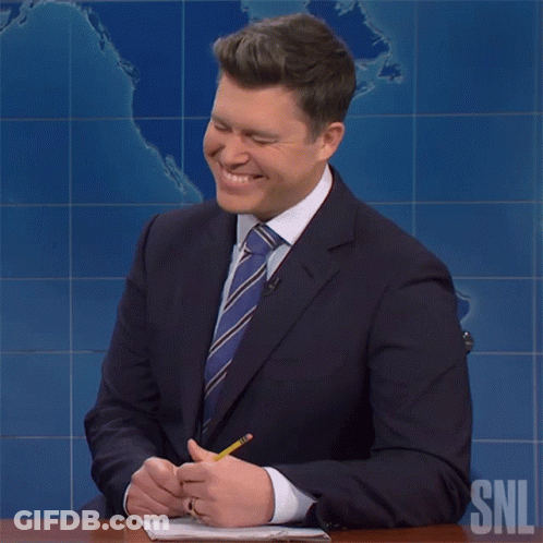 Man In Suit At Desk With SNL Logo GIF