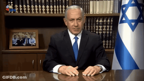 Man In Suit At Desk With Star Of David Flag GIF