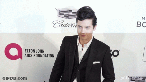 Man In Suit At Elton John AIDS Foundation Banner GIF