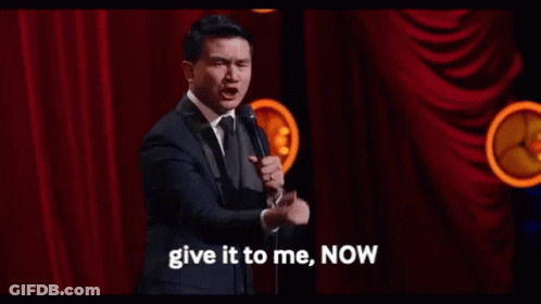 Man In Suit At Mic Says Give It To Me Now GIF