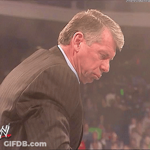 Man In Suit At Microphone In Crowd GIF