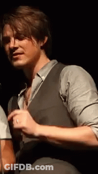Man In Suit At Microphone In Dark Room GIF