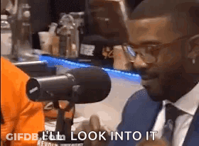 Man In Suit At Microphone Saying I'll Look Into It GIF