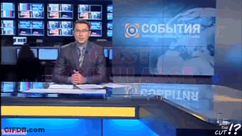 Man In Suit At News Desk With Cobbitnia On Screen GIF