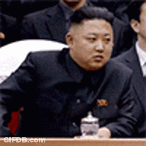 Man In Suit At Podium Holding Bottle GIF